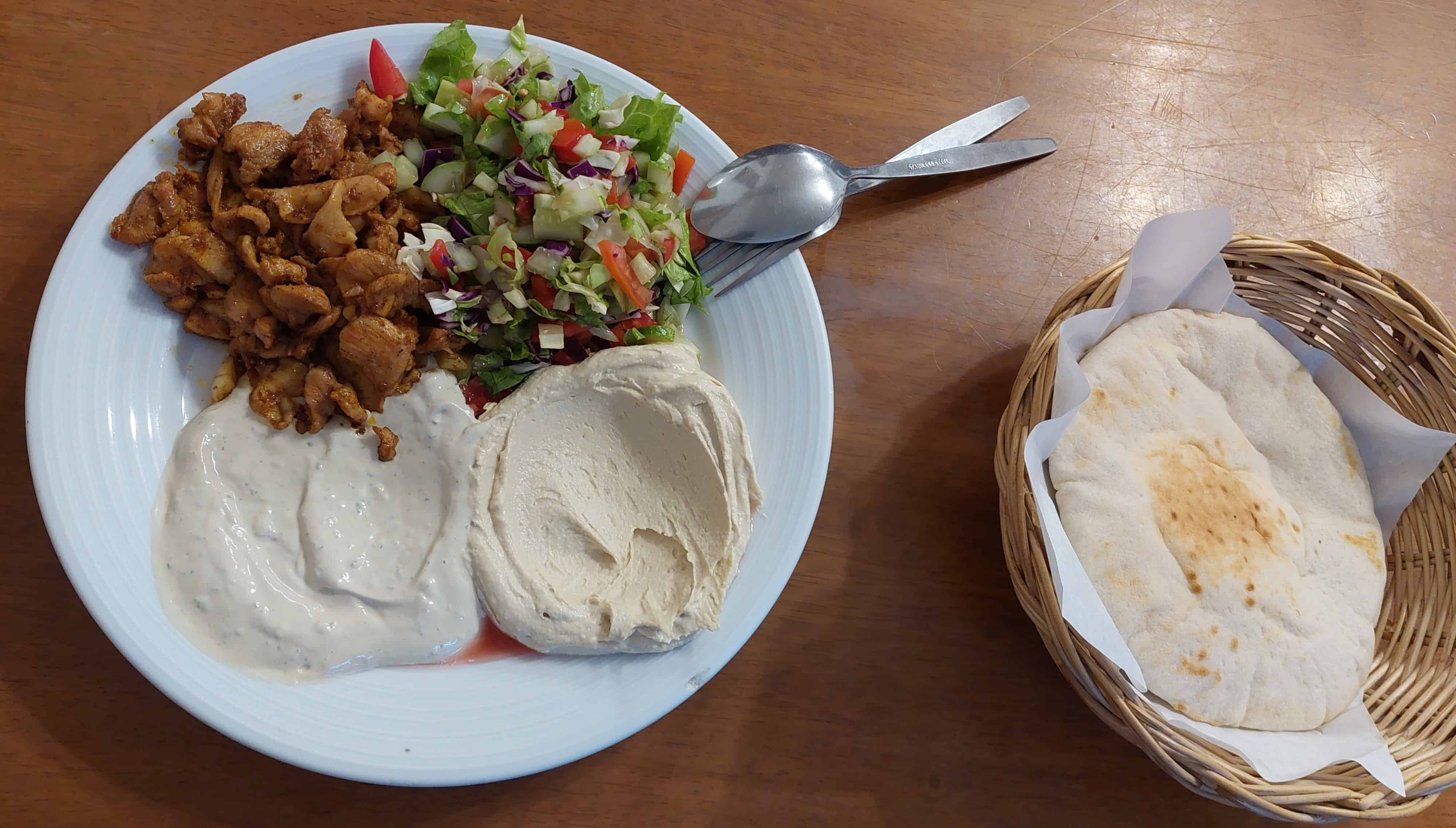 Chicken shawarma plate with tahini, hummus and side-salad. Replace chicken with falafel if you're vegan.
